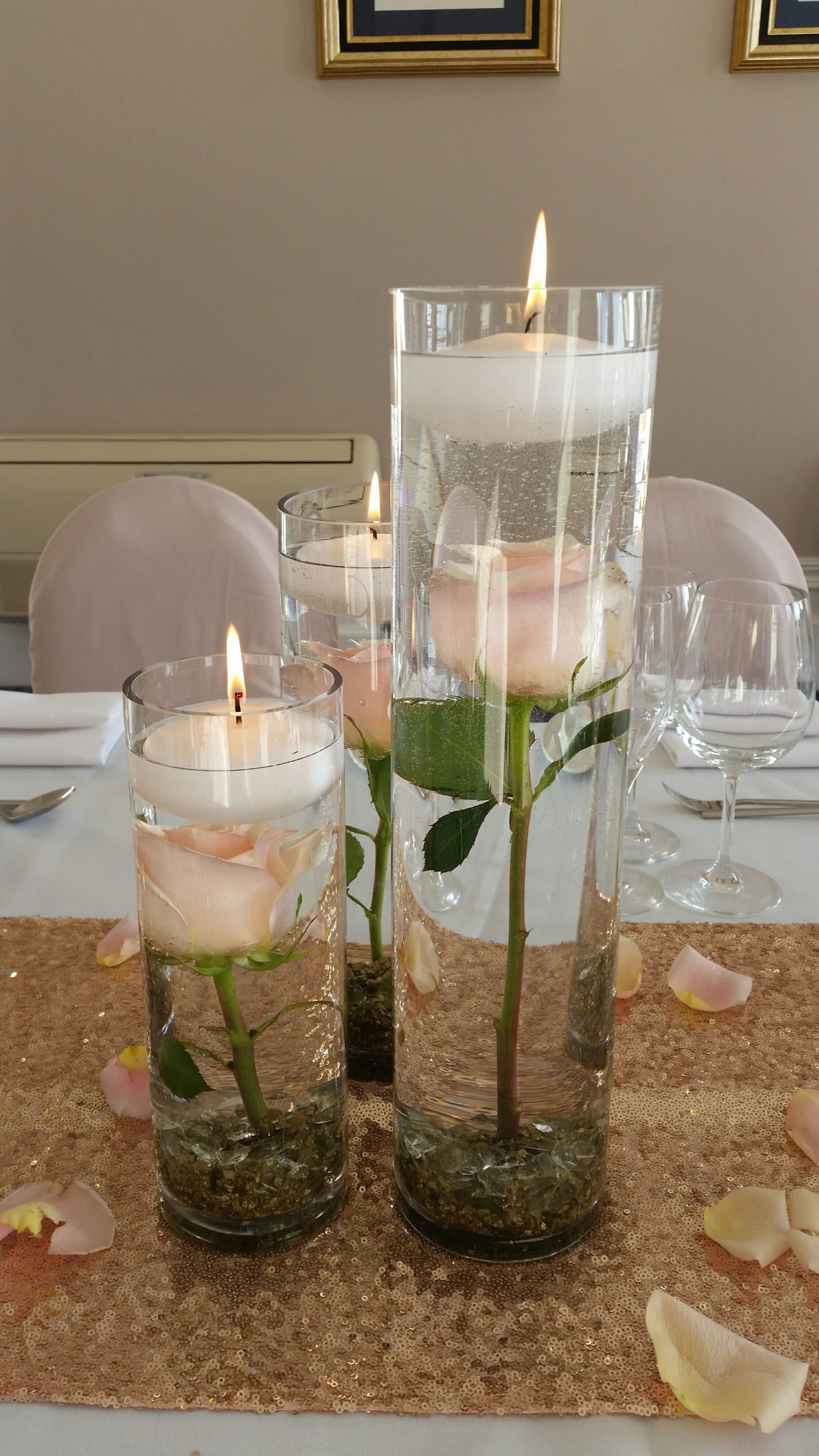 flowers submerged in water with floating candles